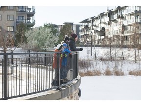 Shelby and Chris Corley, with their children Casper, 8, and Magnus, 10, enjoy the view over a pond at Village at Griesbach, under development by Canada Lands Co.
