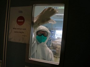 A nurse cleans the window of the COVID-19 Intensive Care Unit of Cascais Hospital amid the COVID-19 pandemic in Cascais, Portugal, Jan. 27, 2021.