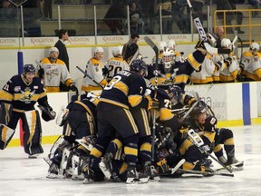 The Spruce Grove Saints mob Cole Basnett after he delivered the game-winning goal in triple overtime of Game 5 of the Alberta Junior Hockey League quarter-final series against the Grande Prairie Storm last year.