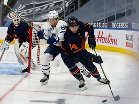 Ethan Bear (74) of the Edmonton Oilers battles against William Nylander (88) of the Toronto Maple Leafs at Rogers Place on Jan. 28, 2021.