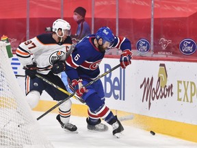 Connor McDavid #97 of the Edmonton Oilers and Shea Weber #6 of the Montreal Canadiens chase the puck during the first period at the Bell Centre on February 11, 2021.