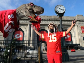 A Kansas City Chiefs fan in a full Native American headdress poses in front of a dinosaur statue clothed in a Kansas City Chiefs jersey as a Tampa Bay Buccaneer effigy dangles from his mouth, outside of Union Station in downtown Kansas City ahead of Super Bowl LV on Feb. 01, 2021 in Kansas City, Mi.