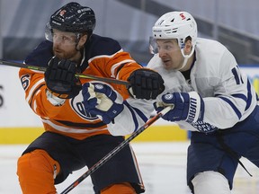 The Edmonton Oilers' Adam Larsson (6) battles the Toronto Maple Leafs' Zach Hyman (11) at Rogers Place in Edmonton on Saturday Feb. 27, 2021.