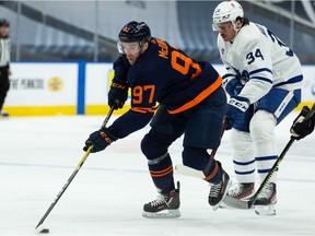 Edmonton Oilers' Connor McDavid (97) battles Toronto Maple Leafs' Auston Matthews (34) during first period NHL action at Rogers Place in Edmonton, on Thursday, Jan. 28, 2021.