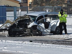 Police investigate as an engine sits on the roadway after being dislodged from a vehicle in a horrific single vehicle collision that struck a large metal traffic post sending the driver to hospital with critical injures where he later died in Edmonton on Monday, Feb. 8, 2021.