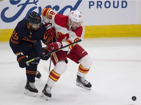Edmonton Oilers Darnell Nurse (25) battles for the puck with Calgary Flames Nikita Nesterov (89) during first period NHL action on Saturday, Feb. 20, 2021 in Edmonton.