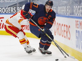 Edmonton Oilers forward Connor McDavid (97) moves the puck past Calgary Flames forward Elias Lindholm (28) during the first period at Rogers Place on Feb. 20, 2021.