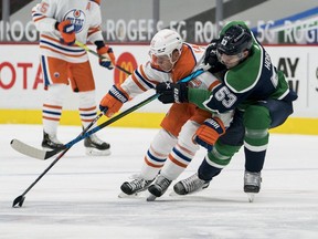 Vancouver Canucks forward Bo Horvat (53) checks Edmonton Oilers forward Dominik Kahun (21) in the first period at Rogers Arena on Feb. 25, 2021.