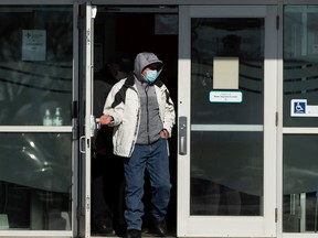 A man in a mask exits an AHS COVID-19 vaccination clinic in north Edmonton, on Wednesday, Feb. 24, 2021.