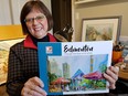 Artist Deb Achtymichuk, holds a copy of Edmonton Through the Eyes of Its Artists.