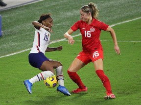 US defender Crystal Dunn (L) challenges forward Janine Beckie of Canada during their SheBelieves Cup international soccer tournament game at Exploria Stadium in Orlando, Florida on February 18, 2021.