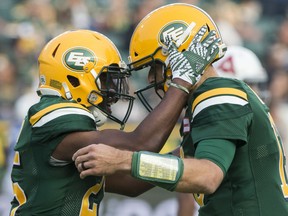 Edmonton Football Team running back Shaquille Cooper (25) celebrates his touchdown against the Montreal Alouettes with quarterback Mike Reilly (13) in this file photo from August 18, 2018, in Edmonton.