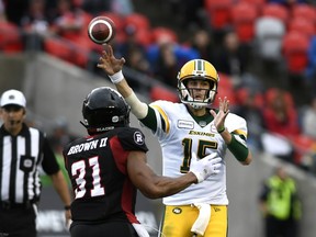 Edmonton Football Team quarterback Logan Kilgore (15) throws the ball under pressure from Ottawa Redblacks linebacker Kevin Brown II (31) in Ottawa on Sept. 28, 2019.