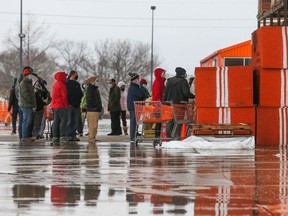 Customers wait outside on February 17, 2021 at a Home Depot in Pearland, Texas to enter the store to buy supplies. - The store would only let one person in at a time because the store has no power. A winter storm has caused rolling black-outs through out the Houston and the surrounding areas for the past 48 hours. Millions of Americans were struggling without electricity Wednesday as bitter cold from a deadly winter storm system held its grip across huge swathes of the United States, even pushing as far south as Mexico.