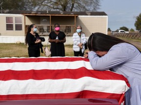 Lila Blanks reacts next to the casket of her husband, Gregory Blanks, 50, who died from complications from the coronavirus disease (COVID-19), ahead of his funeral in San Felipe, Texas, U.S., January 26, 2021.