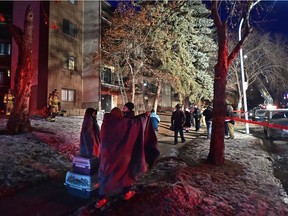 Residence wrapped in blankets with pets in their carriers of an apartment on 65 St. near 129 Ave. were evacuated due to a fire in northeast Edmonton, February 24, 2021.