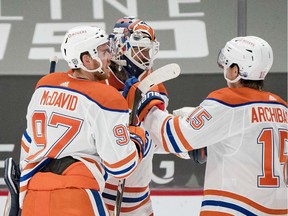 Feb 23, 2021; Vancouver, British Columbia, CAN; Edmonton Oilers forward Connor McDavid (97) and goalie Mike Smith (41) and forward Josh Archibald (15) celebrate their victory against the Vancouver Canucks in the third period at Rogers Arena. Oilers won 4-3.