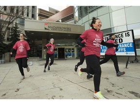 Members of the Cardiovascular Intensive Care Unit jog outside the Mazankowski Alberta Heart Institute, in Edmonton, Friday, Feb. 26, 2021.
