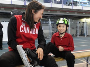 Olympic speed skater Anastasia Bucsis gives Jackson Jones, 8, from the Calgary Speed Skating Association , a hand tying up his skates after the 2014 Canadian Olympic Long-Track Speed Skating Team names were announced at the Olympic Oval in Calgary. Calgary Herald files