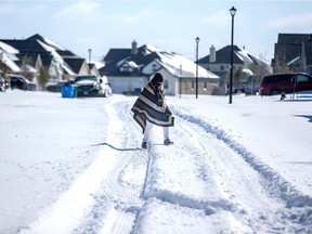 A man walks to his friend's home in a neighbourhood without electricity as snow covers the BlackHawk neighborhood in Pflugerville, Texas, U.S. February 15, 2021. Picture taken February 15, 2021.