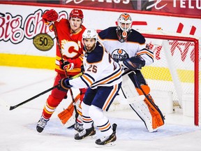 Matthew Tkachuk of the Calgary Flames battles in front of the net against Darnell Nurse of the Edmonton Oilers during an NHL game at Scotiabank Saddledome on Feb. 19, 2021, in Calgary.