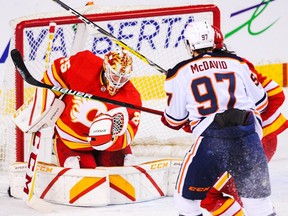 Jacob Markstrom #25 of the Calgary Flames stops a shot from Connor McDavid #97 of the Edmonton Oilers during the first period of an NHL game at Scotiabank Saddledome on March 15, 2021.