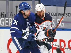 Zack Kassian (44) of the Edmonton Oilers battles against John Tavares (91) of the Toronto Maple Leafs during an NHL game at Scotiabank Arena on March 27, 2021, in Toronto.