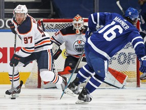 Connor McDavid (97) of the Edmonton Oilers turns the puck up ice against Mitchell Marner (16) of the Toronto Maple Leafs at Scotiabank Arena on March 27, 2021, in Toronto.