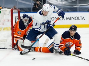 Edmonton Oilers goaltender Mike Smith (41) and Caleb Jones (82) battle Toronto Maple Leafs’ Zach Hyman (11) during second period NHL action at Rogers Place in Edmonton, on Monday, March 1, 2021.