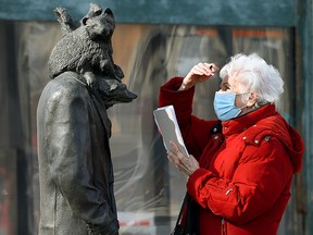 A woman studies a sculpture titled Wild Life by artist Brandon Vickerd, along 96 Street north of 103 Avenue, in Edmonton Wednesday March 3, 2021. Photo by David Bloom