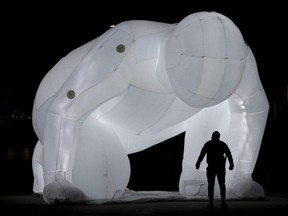 A man appears to stare down a giant inflatable sculpture in Edmonton's Churchill Square, Monday Monday March 22, 2021. The sculpture is one of six large-scale art installations titled Fantastic Planet, that have been installed downtown as part of the Downtown Spark event. Downtown Spark is a program designed to support economic recovery amid the COVID-19 pandemic, by drawing visitors to the downtown core. The event runs through April and includes a series of free exhibits and exhibitions. Photo by David Bloom