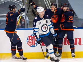 Edmonton Oilers’ Leon Draisaitl (29) celebrates a goal on Winnipeg Jets’ goaltender Connor Hellebuyck (37) with teammates during third period NHL action at Rogers Place on March 20, 2021.