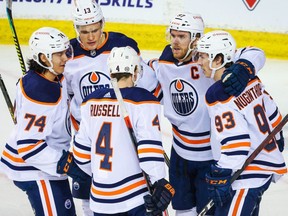 Edmonton Oilers center Ryan Nugent-Hopkins (93) celebrates his goal with teammates Kris Russell (4), Ethan Bear (74), Jesse Puljujarvi (13) and Connor McDavid (97) against the Calgary Flames during the first period at Scotiabank Saddledome on March 17, 2021.