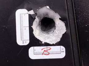 A bullet hole is seen in a bystander's SUV after Edmonton Police Service officers investigated an early morning shooting in an alley near 103 Street and 132 Avenue in Edmonton, on Friday, March 26, 2021.