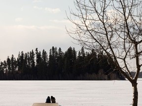 Two people take a moment on the dock at Astotin Lake at Elk Island National Park outside of Edmonton, on Tuesday, March 30, 2021. Photo by Ian Kucerak