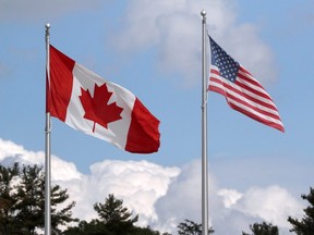 FILE PHOTO: A U.S. and a Canadian flag flutter at the Canada-United States border crossing at the Thousand Islands Bridge, which remains closed to non-essential traffic to combat the spread of the coronavirus disease (COVID-19) in Lansdowne, Ont., on September 28, 2020.
