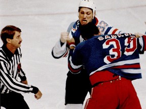 Edmonton Oilers tough guy Marty McSorley punches it out with New York Rangers Terry Carkner as NHL linesman Swede Knox stands by in 1987 at Northlands Coliseum in Edmonton.