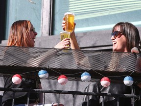 Larissa Murphy and Terrell O'Brien cheers to the spring weather while enjoying a drink on the patio of One Night Stan's Bar Room and Divery on 17th Ave. SW Friday, March 12, 2021.