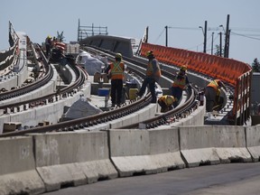 Construction workers prepare the Valley Line LRT along 83 Street near Argyll Road on Wednesday, Aug. 5, 2020 in Edmonton.