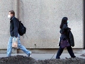 People wearing masks are seen walking down 1st St. SE. Tuesday, March 9, 2021.