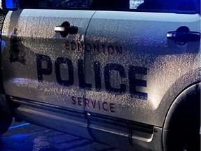 The side of a rain soaked Edmonton Police Service vehicle sits near 96 St., on 78 Ave., while members investigating a police involved shooting in Edmonton, Alta, on Monday, Oct. 19, 2015.