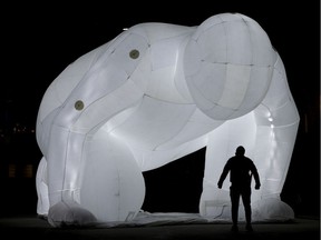 A man appears to stare down a giant inflatable sculpture in Edmonton's Churchill Square, Monday Monday March 22, 2021. The sculpture is one of six large-scale art installations titled Fantastic Planet, that have been installed downtown as part of the Downtown Spark event. Downtown Spark is a program designed to support economic recovery amid the COVID-19 pandemic, by drawing visitors to the downtown core. The event runs through April and includes a series of free exhibits and exhibitions.