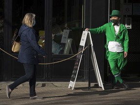 Manager Jimmy Tsang waits to greet St. Patrick's Day customers outside the Malt & Mortar, 10416 82 Ave., in Edmonton, Wednesday, March 17, 2021.