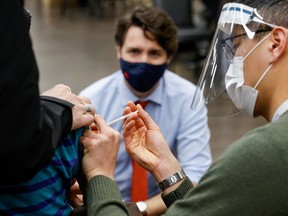 Prime Minister Justin Trudeau watches as nurse Thi Nguyen gives a COVID-19 vaccination at a clinic, as efforts continue to help slow the spread of the coronavirus disease, in Ottawa, Ontario, Canada March 30, 2021.