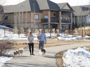 Chelsea and Josh Philpott take a walk with their daughter, Sophie, and dogs Hulk, left, and Leslie, in their new community of Genesis on the Lakes in Stony Plain.