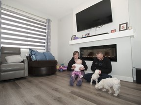 Jessica Stevenson and Marcell Szucs with their daughter, Stella, 11 months, play with their dogs Lucy and Charlie. They love their new home and neighbourhood's dog friendly designs.