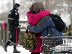 Two camp residents share a hug after being evicted from the homeless camp near downtown Edmonton known as Camp Pekiwewin. Police and peace officers closed the camp down on November 12, 2020. The camp was on public land and had been occupied by over 200 people since July 2020.
