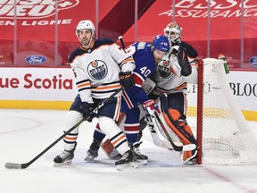 Evan Bouchard (75) of the Edmonton Oilers and Joel Armia (40) of the Montreal Canadiens battle for position in front of Oilers goaltender Mike Smith (41) at the Bell Centre on Feb. 11, 2021, in Montreal.