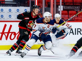 Ottawa Senators left wing Brady Tkachuk (7) checks Edmonton Oilers center Connor McDavid (97) in first period NHL action at the Canadian Tire Centre in Ottawa on Feb. 9, 2021.