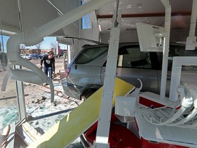 A tow truck operator works to remove an SUV that crashed into the interior of Swish Dental, 16821 127 St., in Edmonton on Thursday April 15, 2021.